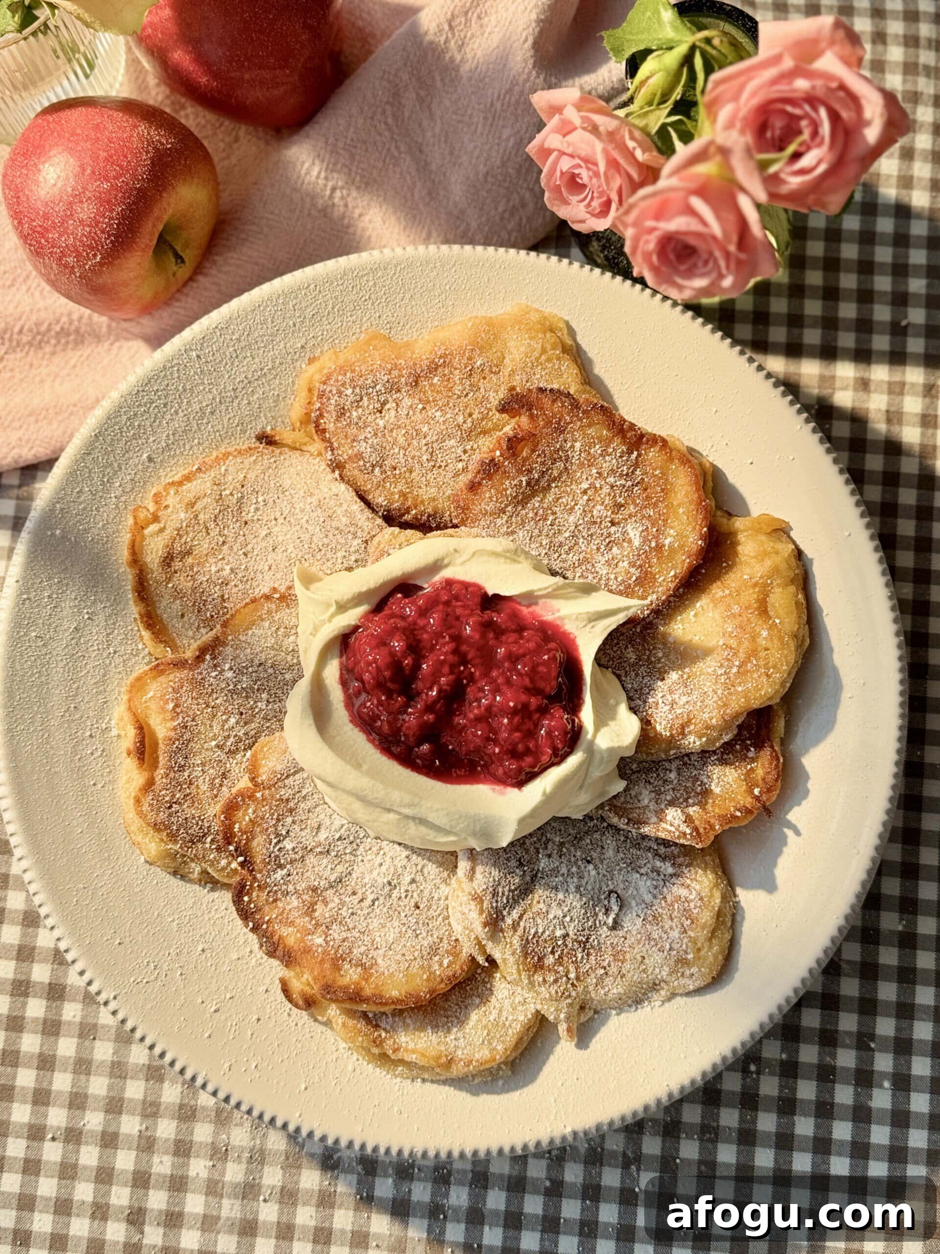 Polish Racuchy: Classic Apple Pancake Recipe You’ll Love 2 racuchy on a white plate with raspberry compote and whipped cream.