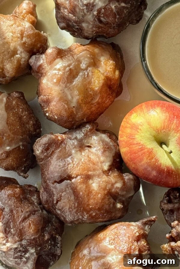 Polish Racuchy: Classic Apple Pancake Recipe You’ll Love 15 applesauce fritters on a plate with an apple.