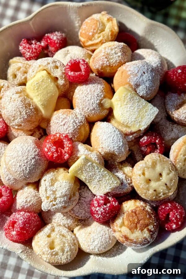 Polish Racuchy: Classic Apple Pancake Recipe You’ll Love 17 poffertjes in bowl with butter and raspberries.