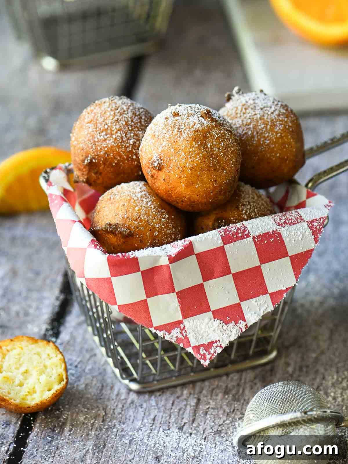 Orange Ricotta Zeppole: Classic Italian Ricotta Doughnut Recipe 2 Ricotta doughnuts in a fry basket with a red checkered liner.