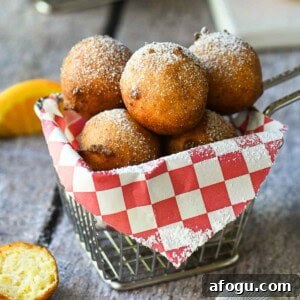 Orange Ricotta Zeppole: Classic Italian Ricotta Doughnut Recipe 13 Ricotta doughnuts in a fry basket with a red checkered liner.
