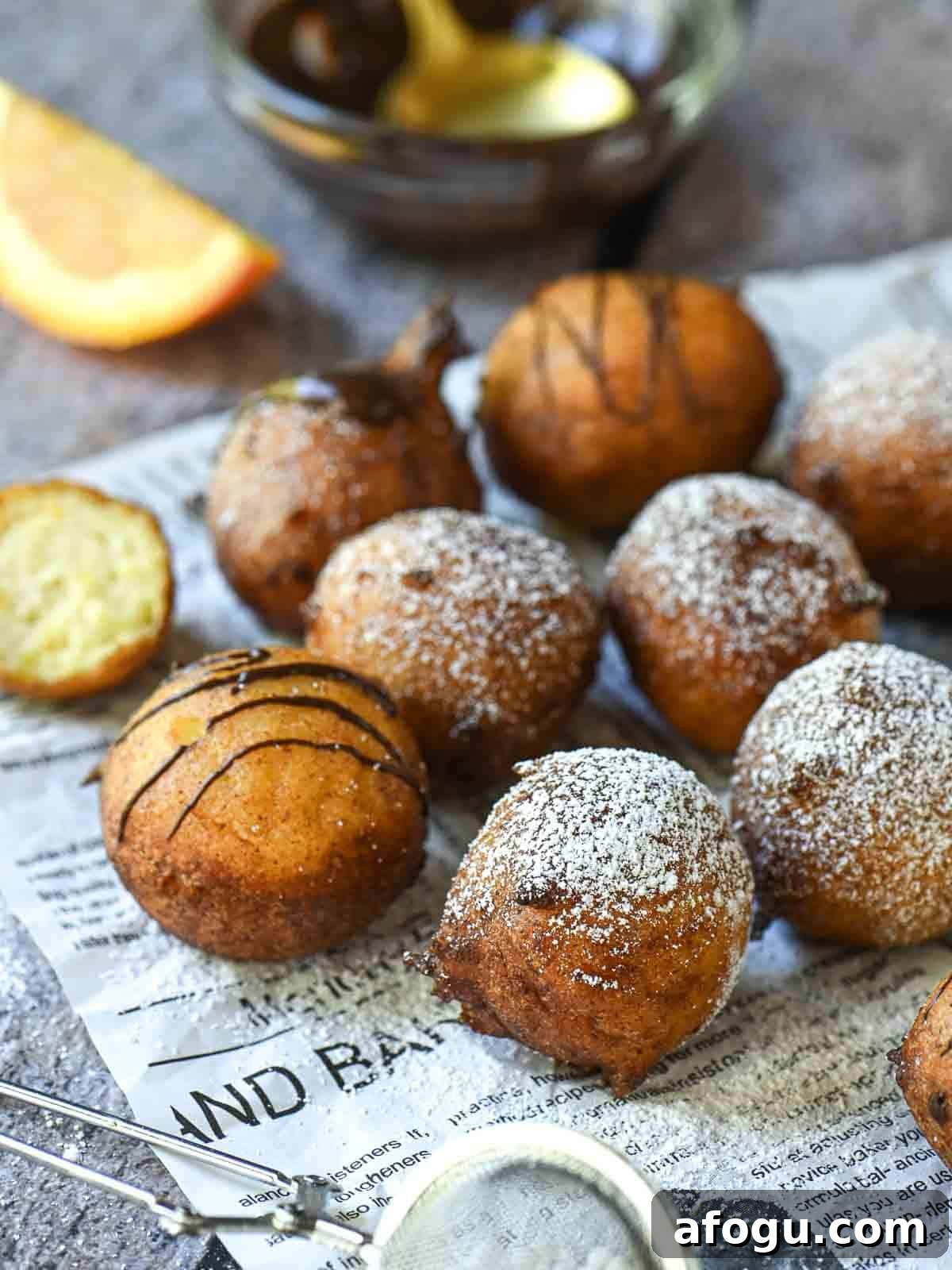 Orange Ricotta Zeppole: Classic Italian Ricotta Doughnut Recipe 8 Orange ricotta donuts on parchment paper with powdered sugar.