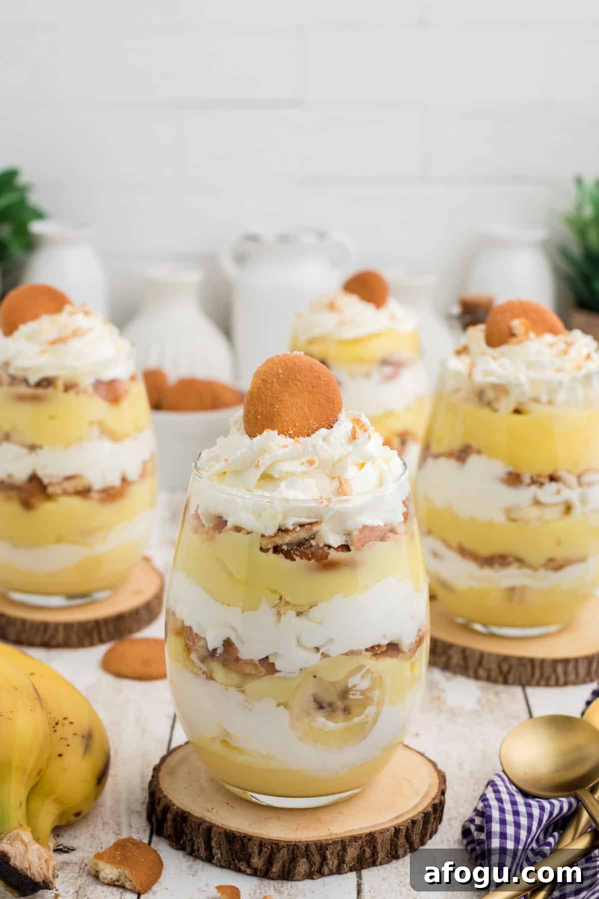 A tall image of some banana pudding cups in glasses.