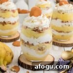 Some banana pudding cups sitting on top of wooden coasters.