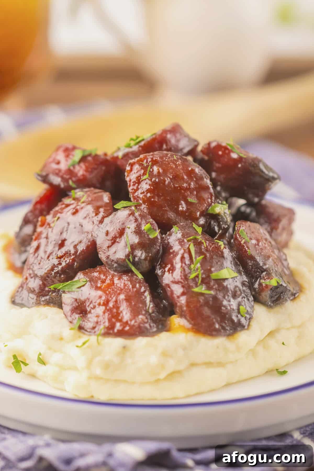 Brown sugar kielbasa on a bed of mashed potatoes.