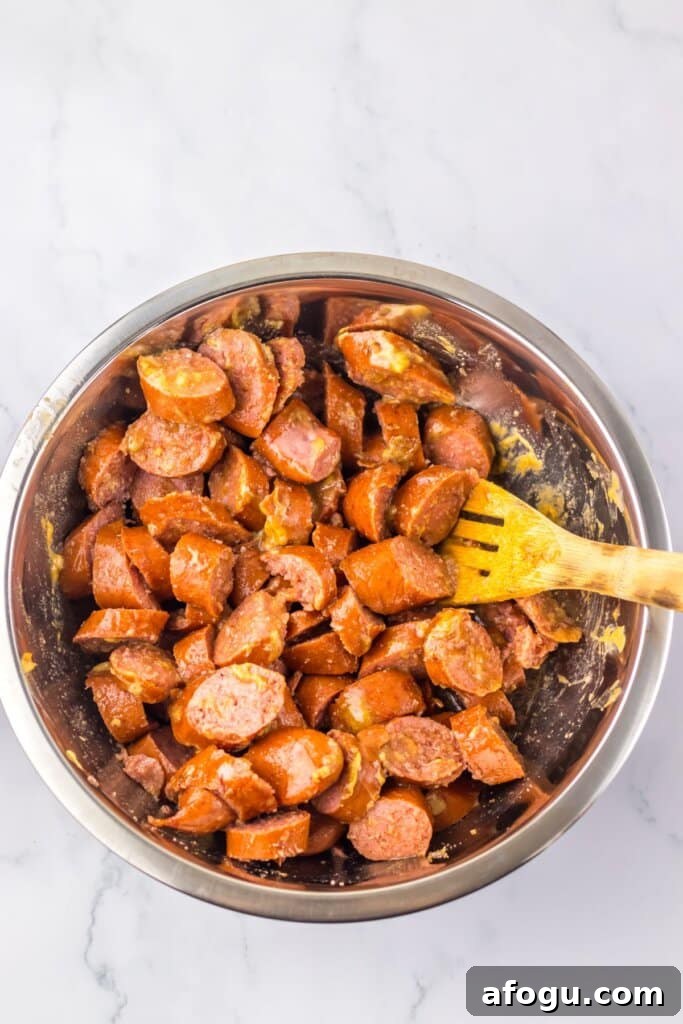 Smoked sausage and being mixed in a bowl.
