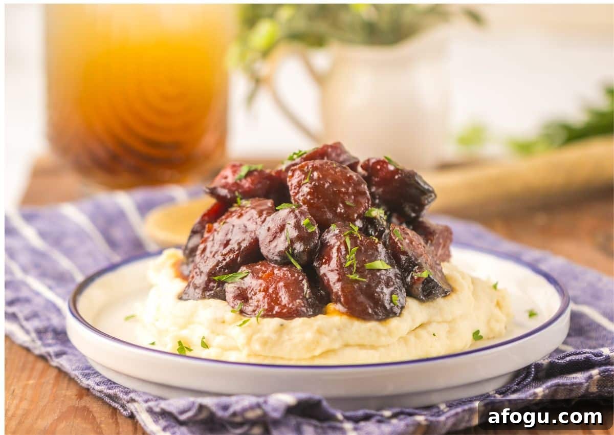 Brown sugar kielbasa on a bed of mashed potatoes.