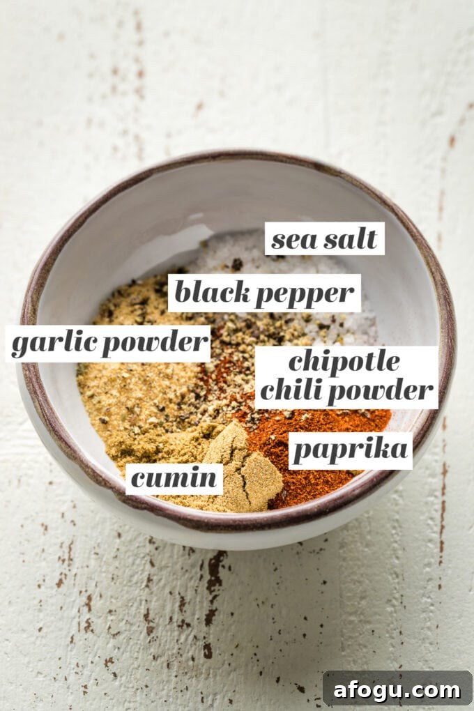 Small prep bowl containing sea salt, black pepper, garlic powder, chipotle chili powder, paprika, and cumin.