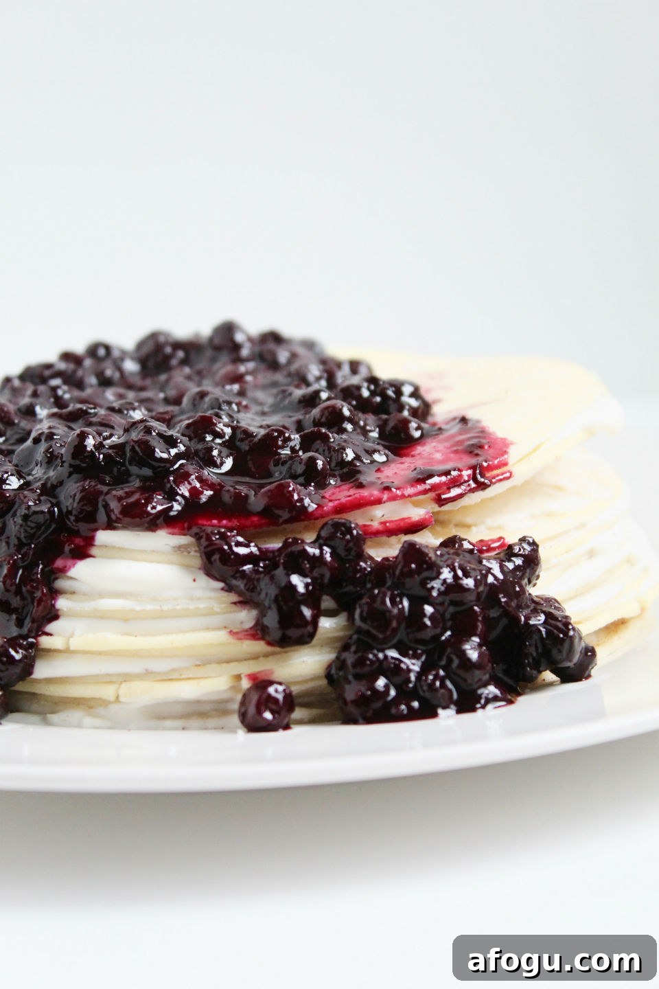 Gluten Free Crepe Cake Recipe & Blueberry Topping Pouring Over Side