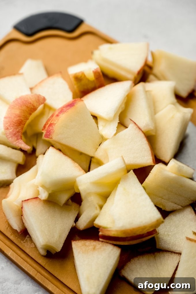 A pile of apple slices on a cutting board.
