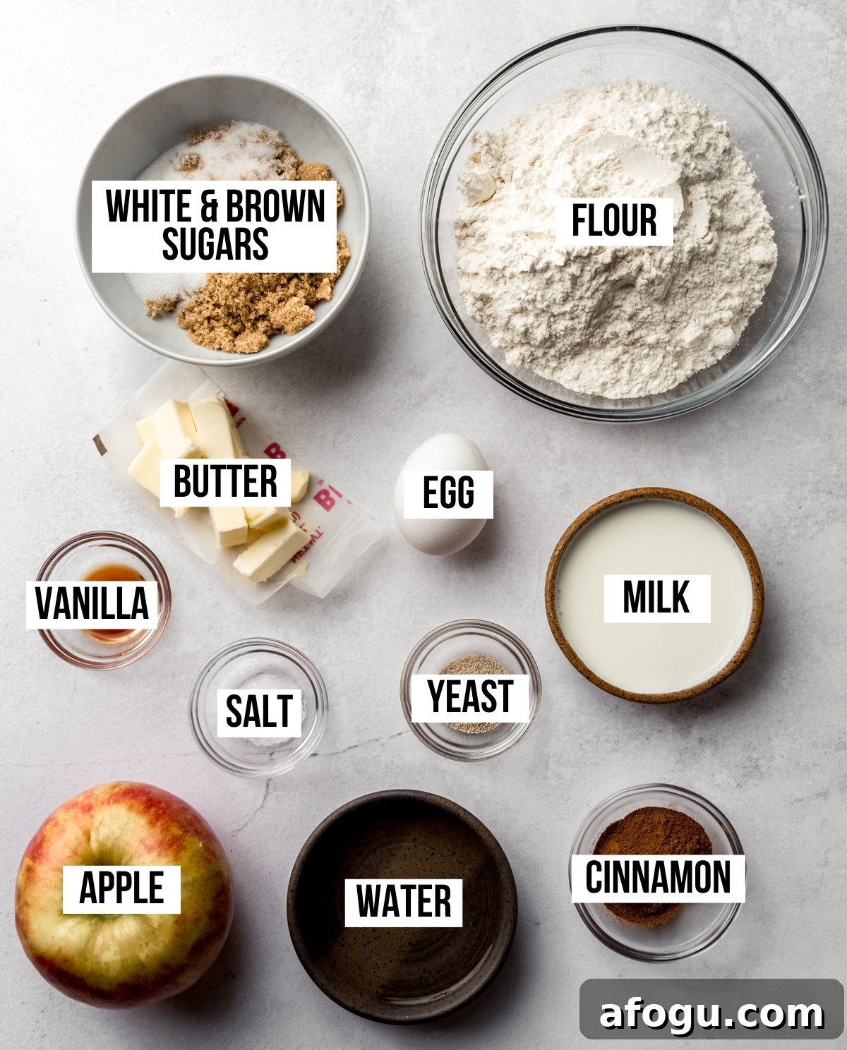 Aerial photo of the ingredients to make apple cinnamon rolls with text overlay labeling each ingredient.
