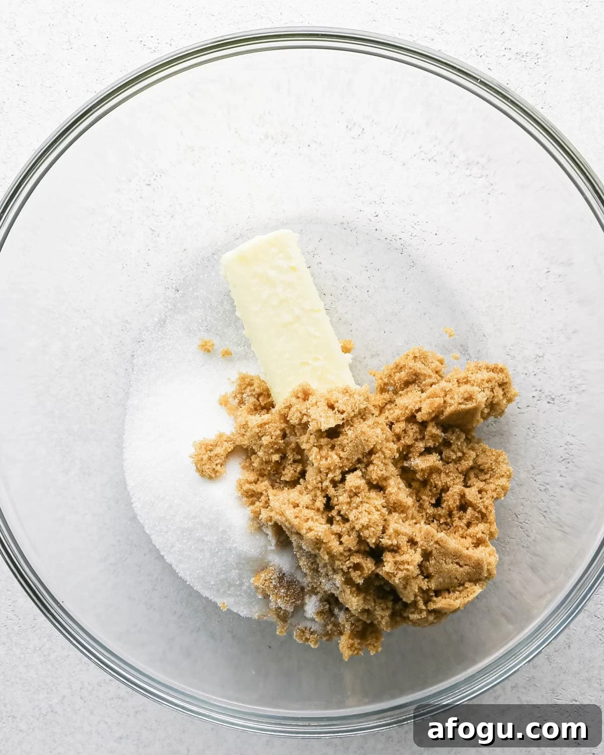 Chocolate Chip Cashew Cookies Recipe — Crunchy Homemade Treats 9 Making chocolate chip cashew cookies: overhead photo of butter, sugar, and brown sugar in a large clear mixing bowl.