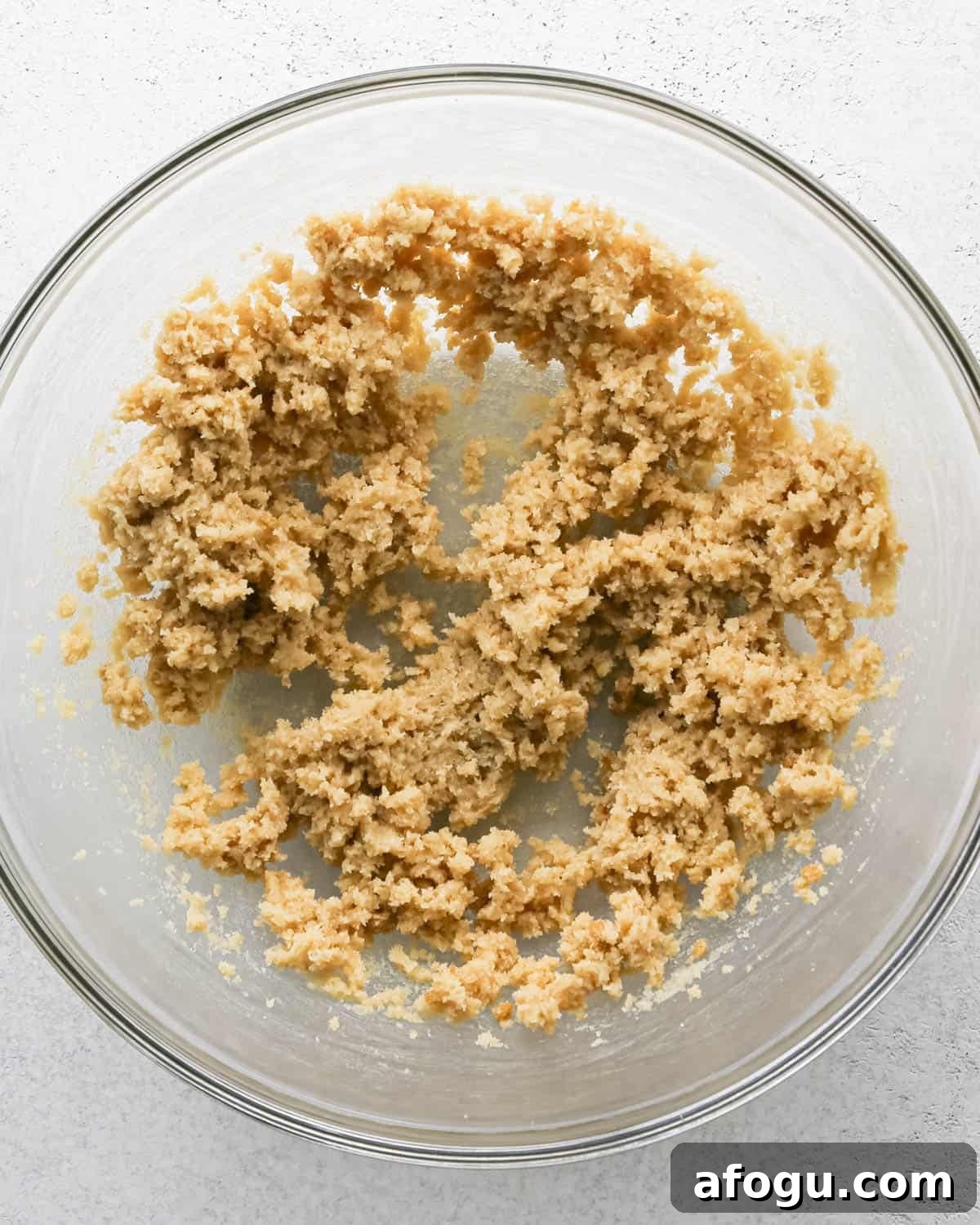 Chocolate Chip Cashew Cookies Recipe — Crunchy Homemade Treats 10 Making chocolate chip cashew cookies: overhead photo of butter, sugar, and brown sugar creamed together in a large clear mixing bowl.
