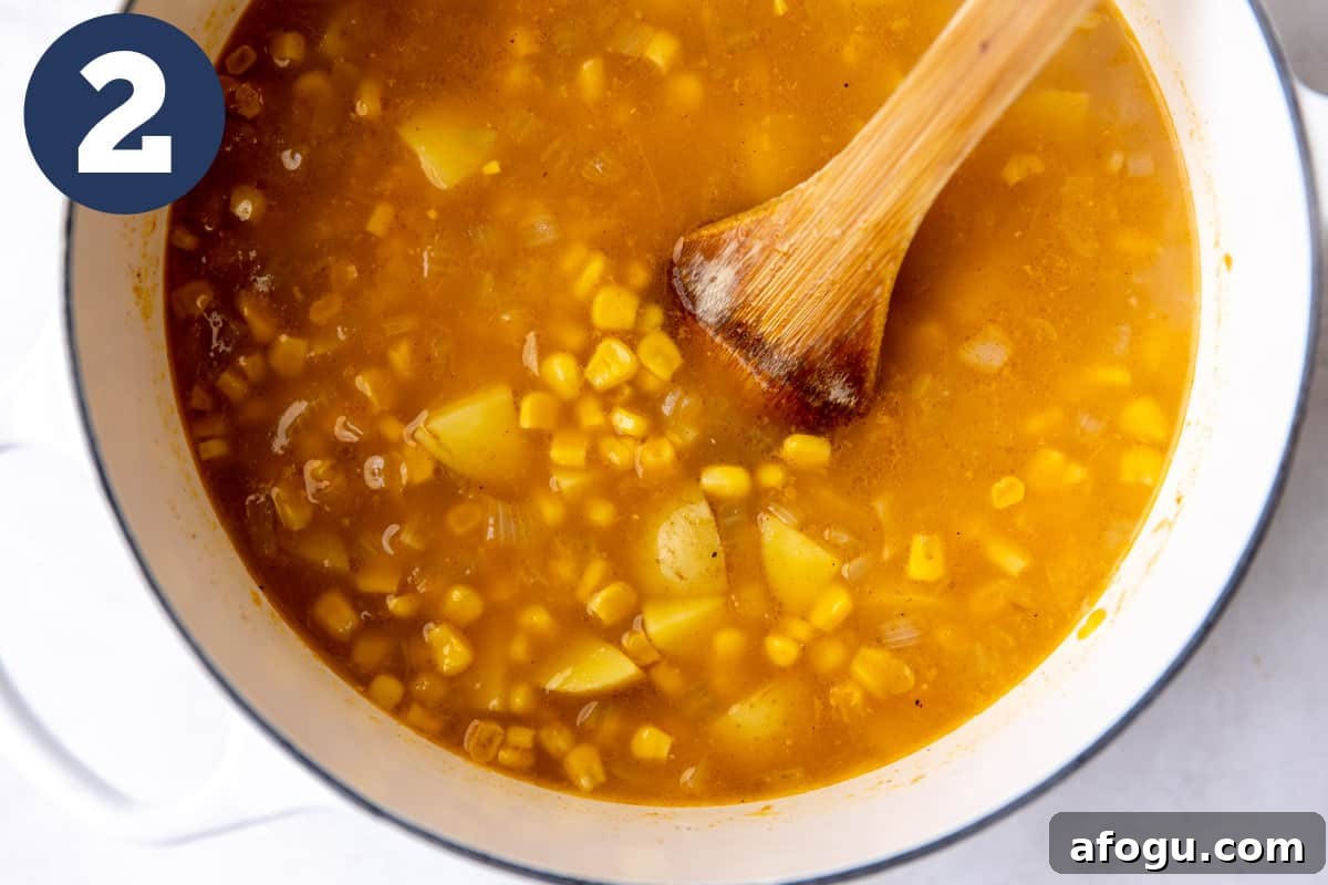 Broth with potatoes and corn in a dutch oven.