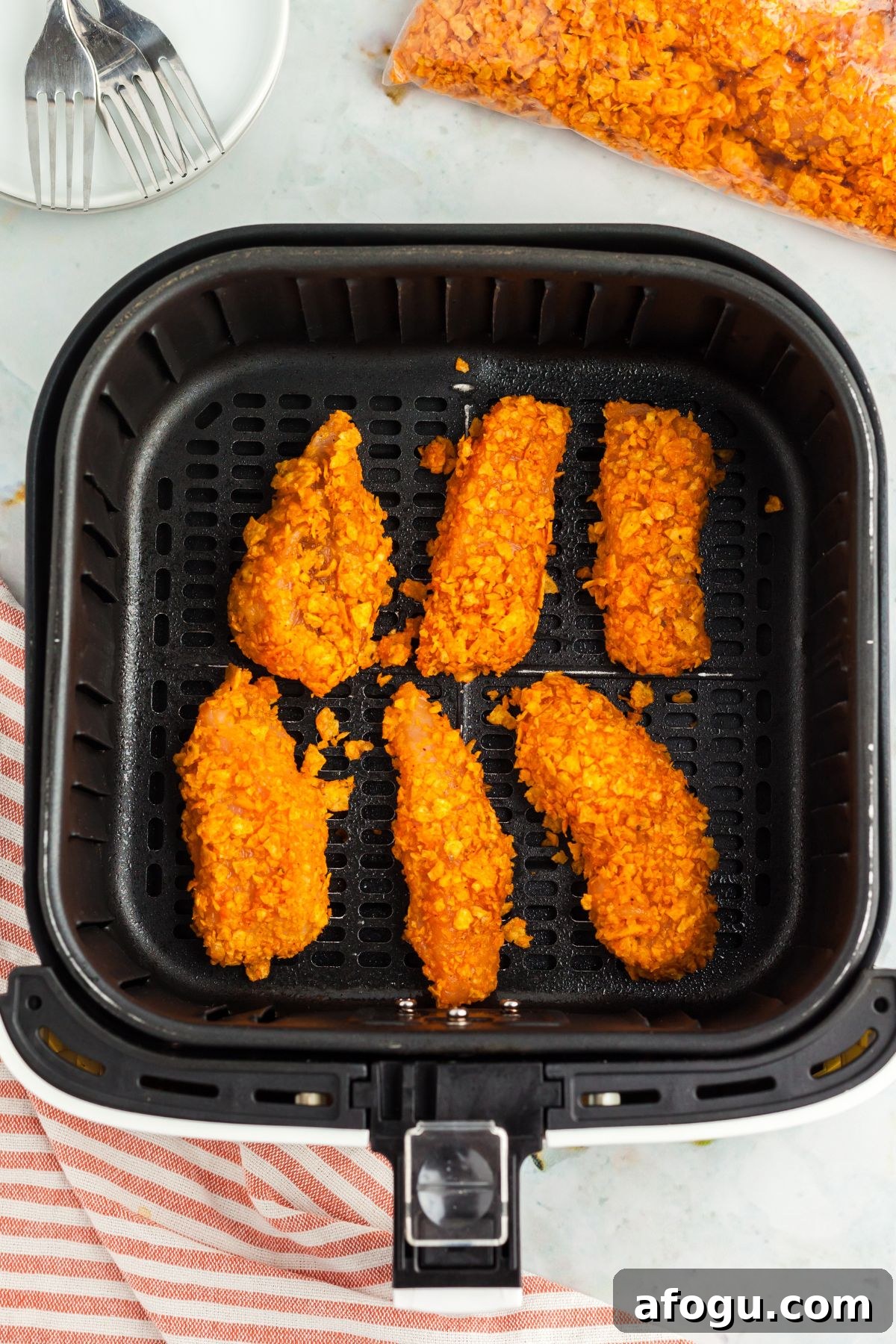Crispy Dorito-Crusted Air Fryer Chicken Recipe 6 Chicken strips coated with crushed dorito chips in the air fryer basket