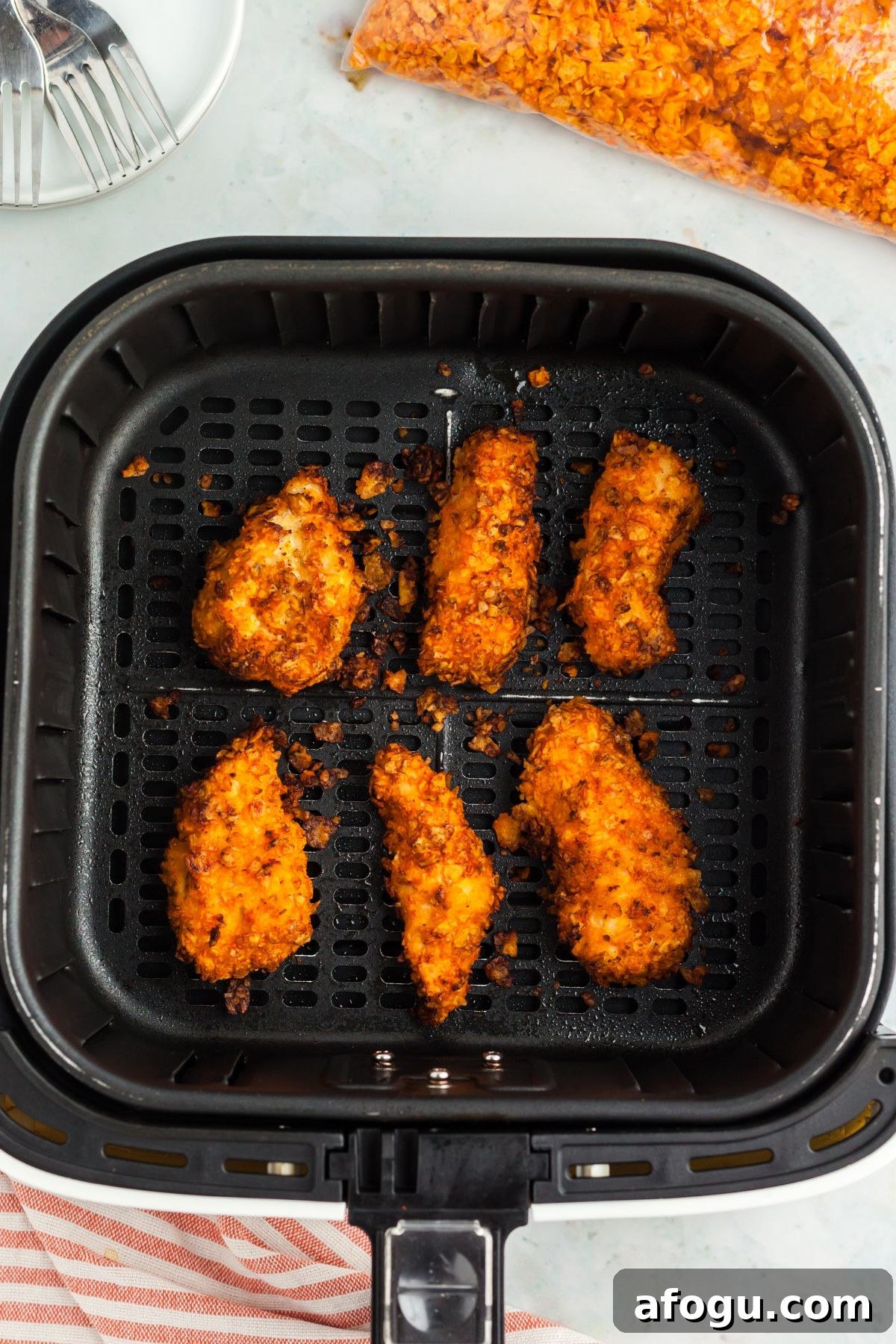 Crispy Dorito-Crusted Air Fryer Chicken Recipe 7 Cooked nacho cheese chip coated chicken tenders in the air fryer basket