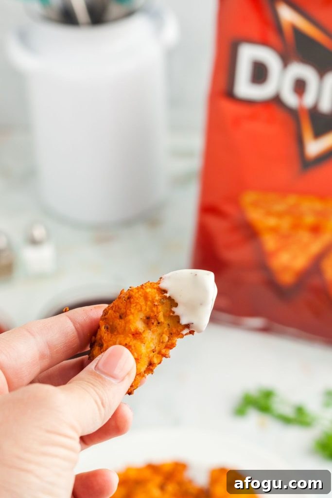 Crispy Dorito-Crusted Air Fryer Chicken Recipe 9 Chicken tender dipped in ranch with dorito bag in background
