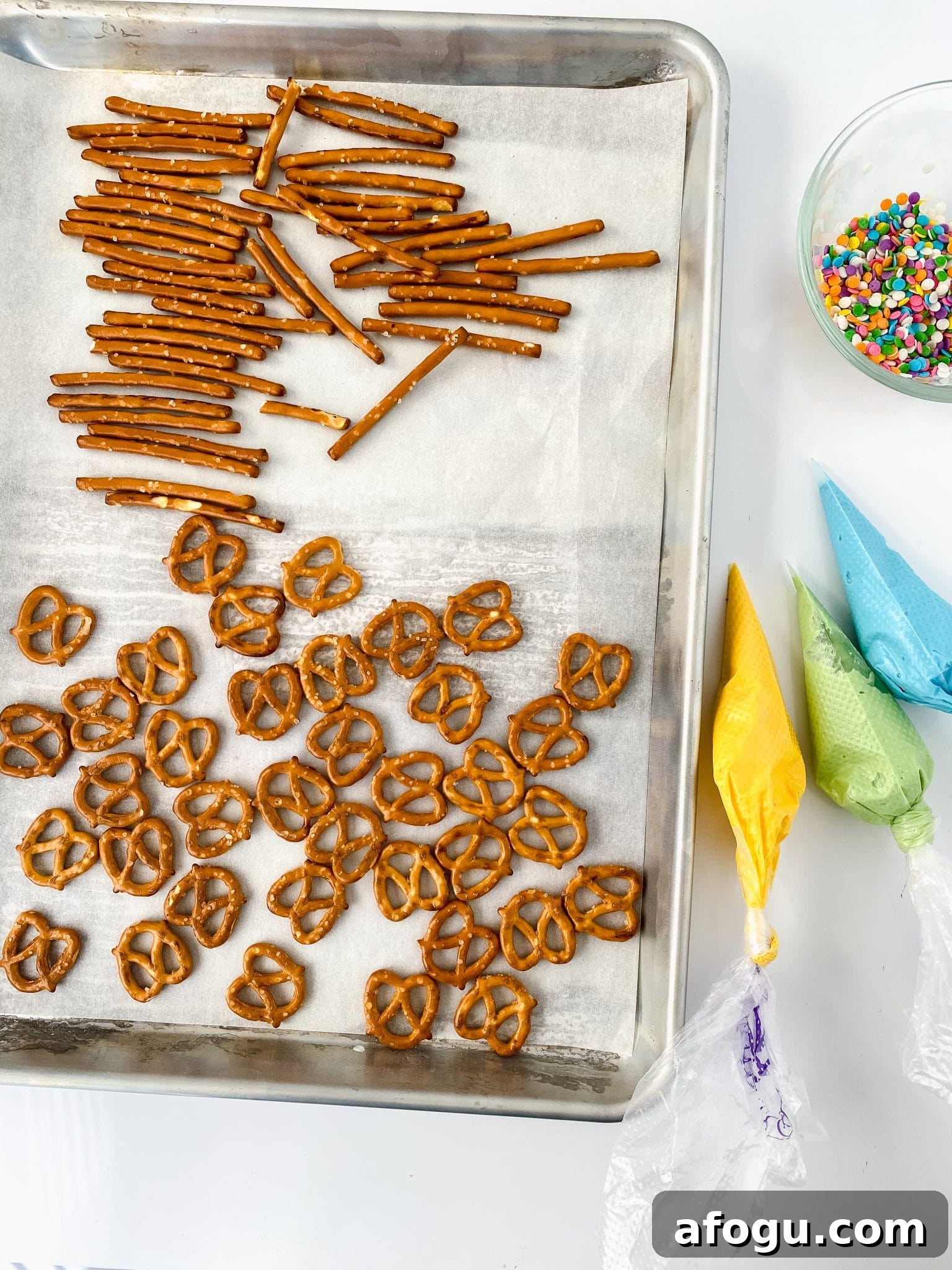 Ingredients to make striped chocolate pretzels and strawberries.