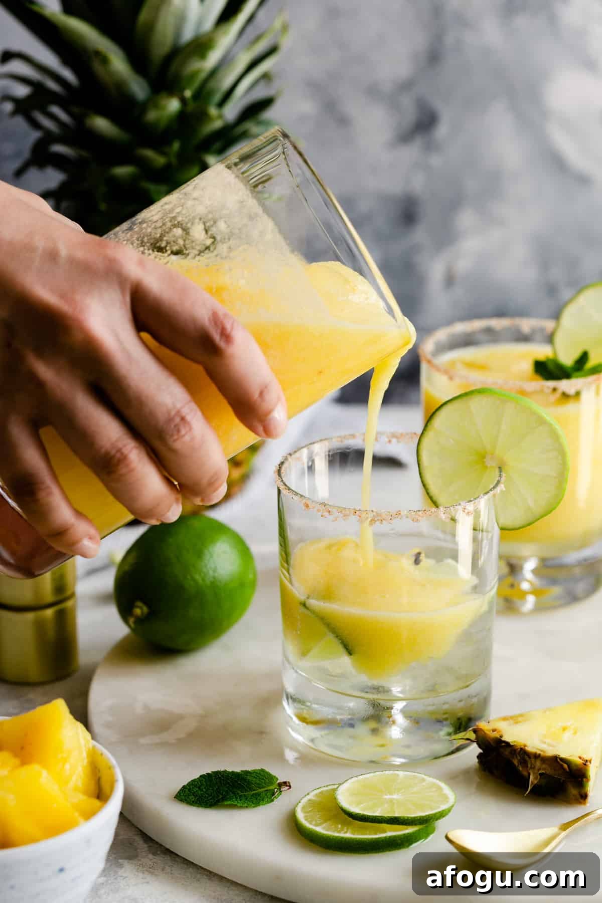 a person pouring a cocktail into a glass