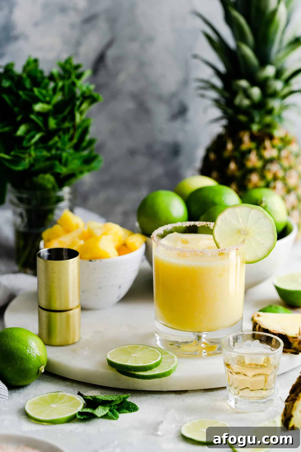 glass of frozen pineapple margarita on a marble chopping board