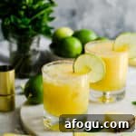 two glasses filled with pineapple margarita cocktail