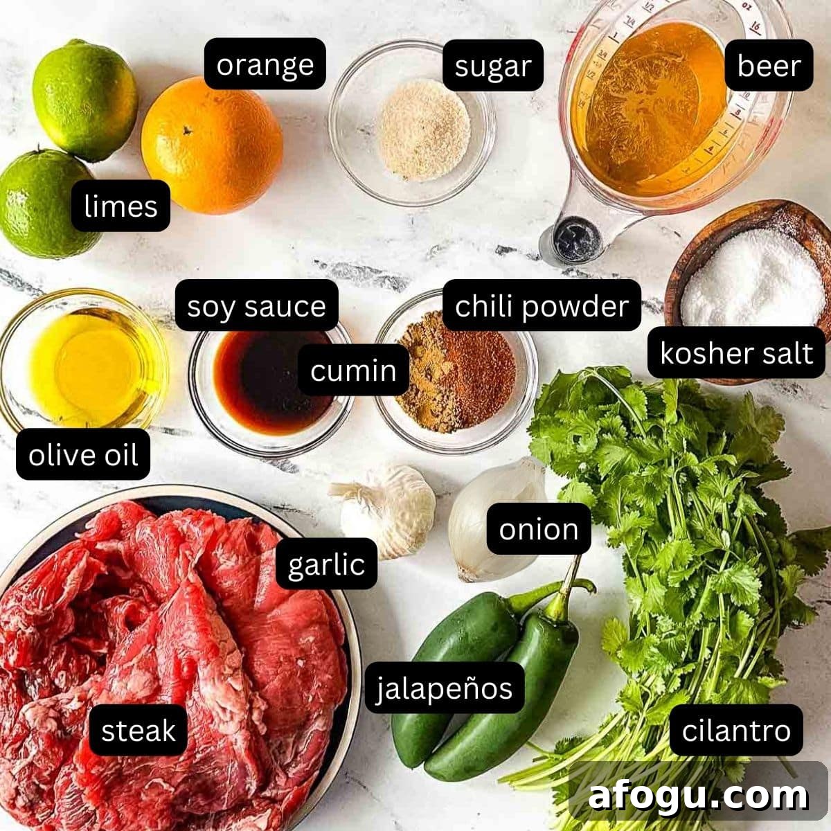 The labeled ingredients for carne asada sit on a white marble counter.