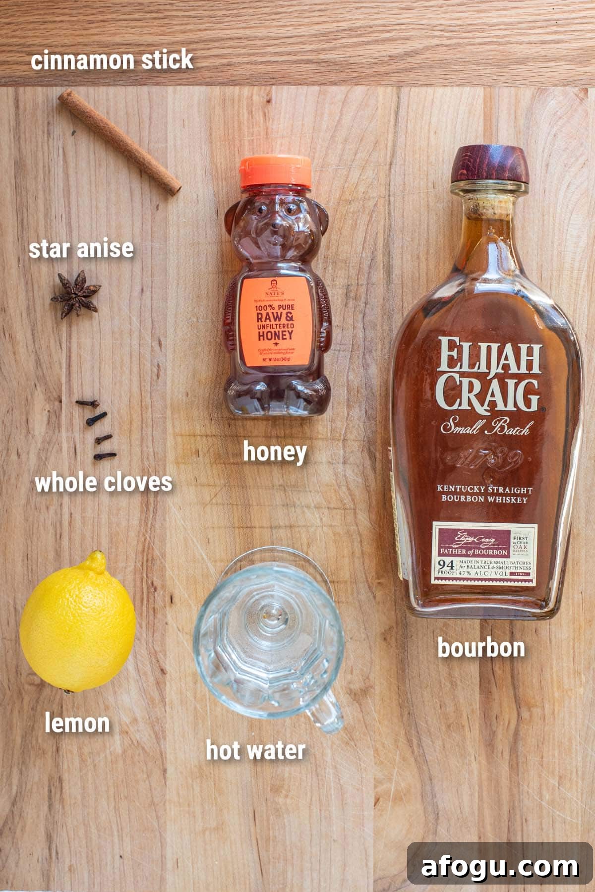 Hot Toddy cocktail ingredients laid out on a wooden cutting board.