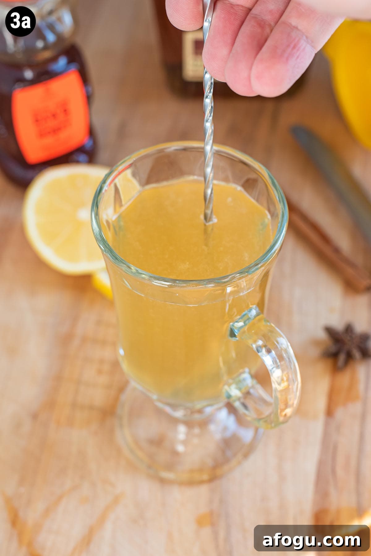 Stirring a Hot Toddy with a metal cocktail stirrer.
