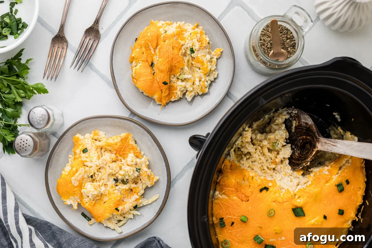 Two plates with slow cooker party potatoes and the rest in a crockpot.