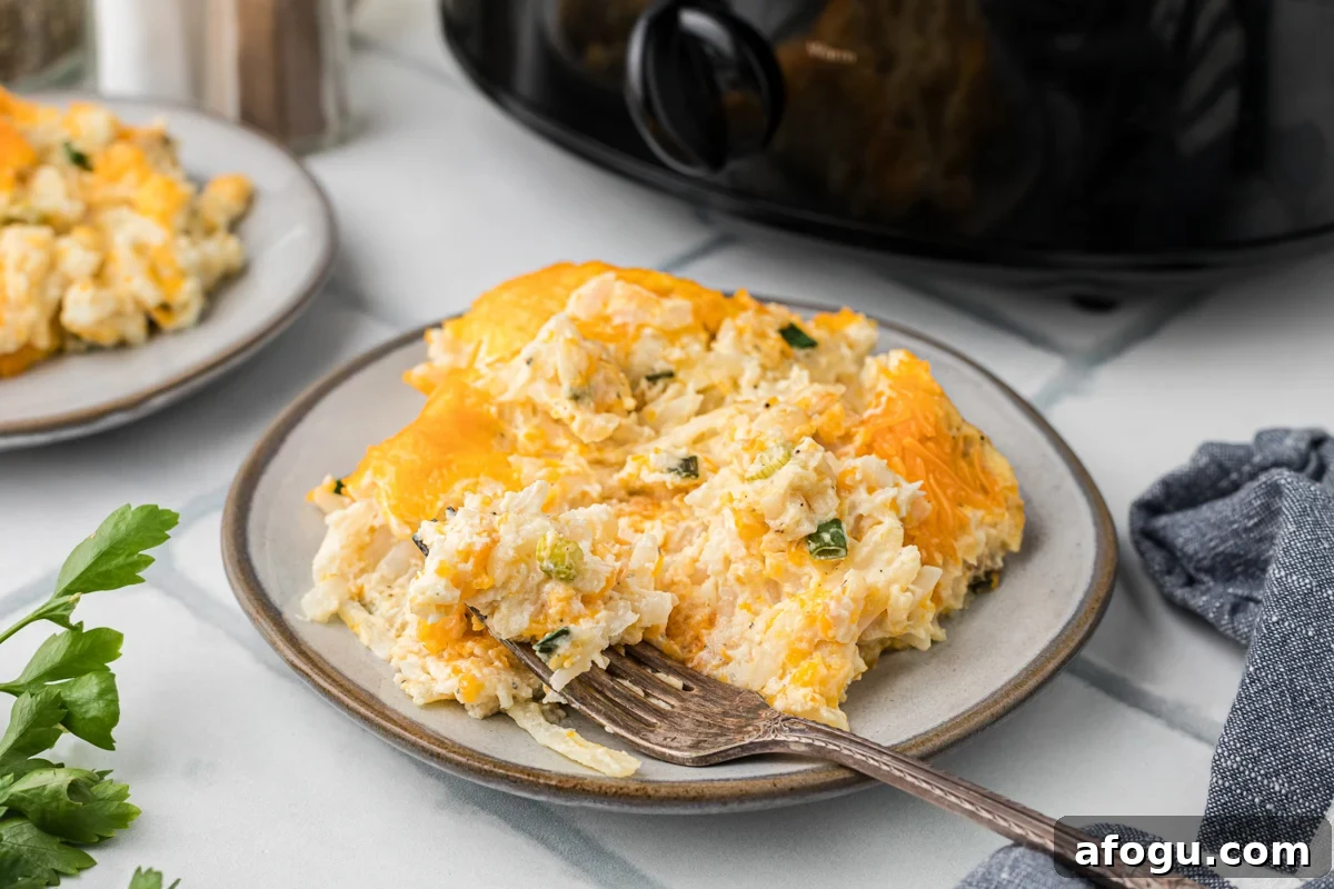 Slow cooker party potatoes on a plate with a fork.