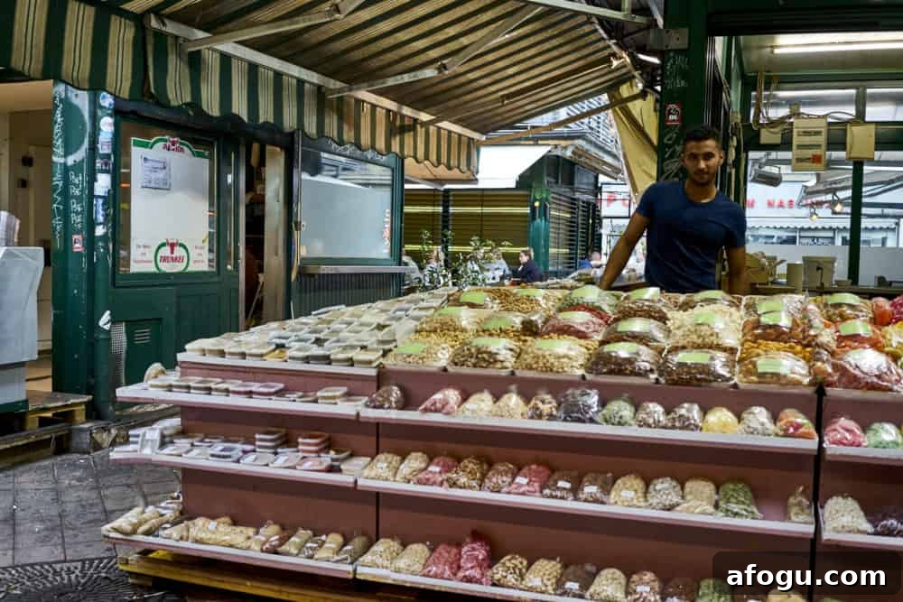 Top Vienna Markets: Where to Shop Local Food, Crafts & Gifts 13 A man working at a stand selling nuts and spices at Naschmarkt in Vienna.