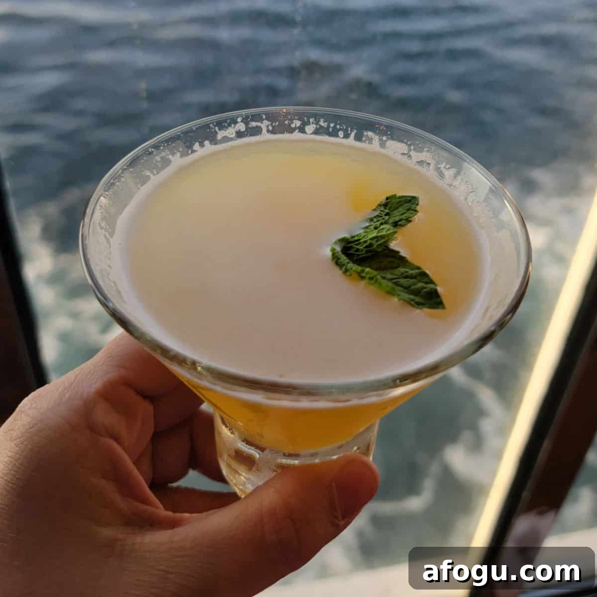 Spicy Chipotle martini in a stemless martini glass with ocean water in the background