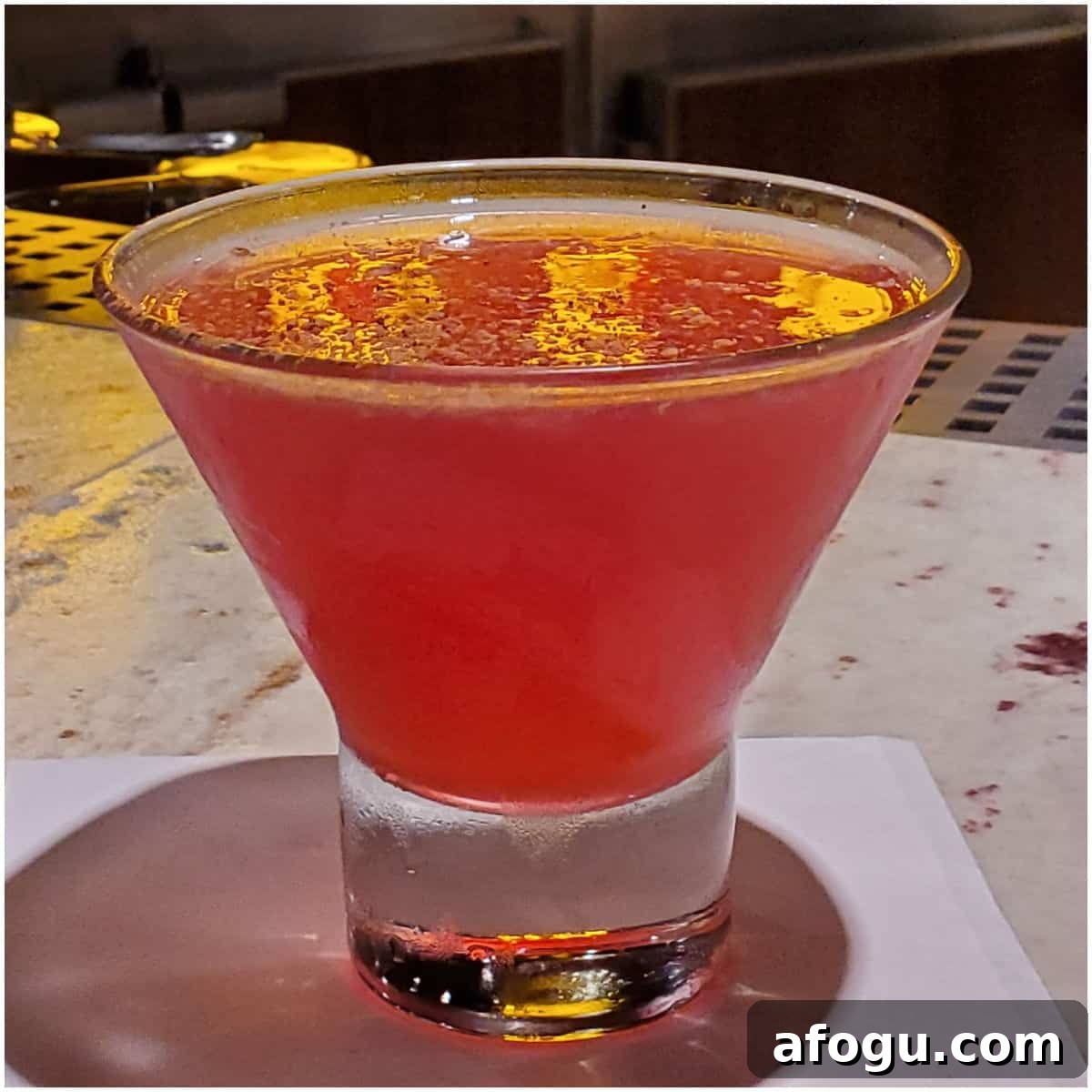 red martini in a stemless martini glass on a white napkin