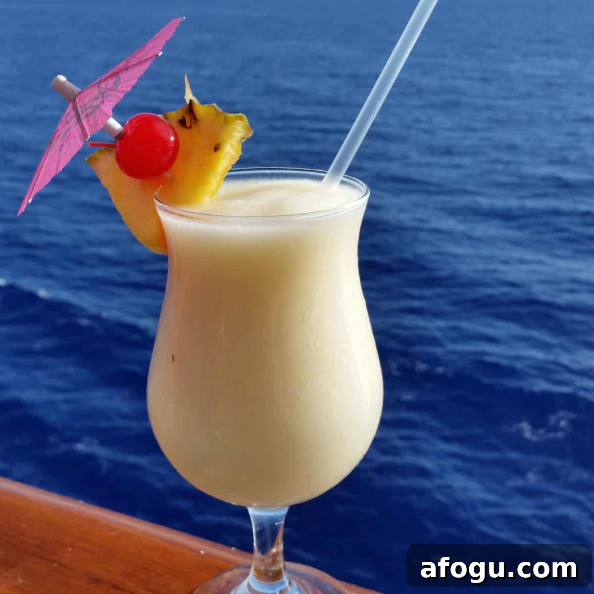 Caribbean Colada in a hurricane glass with pineapple wedge and cherry garnish