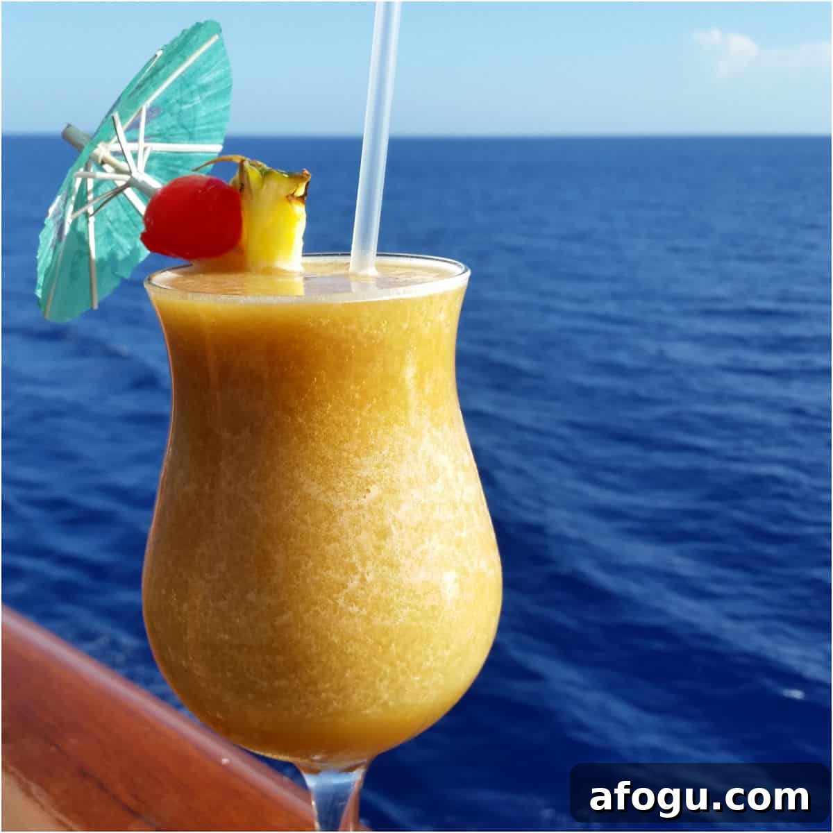 Yellow dirty banana cocktail in a hurricane glass with the ocean background