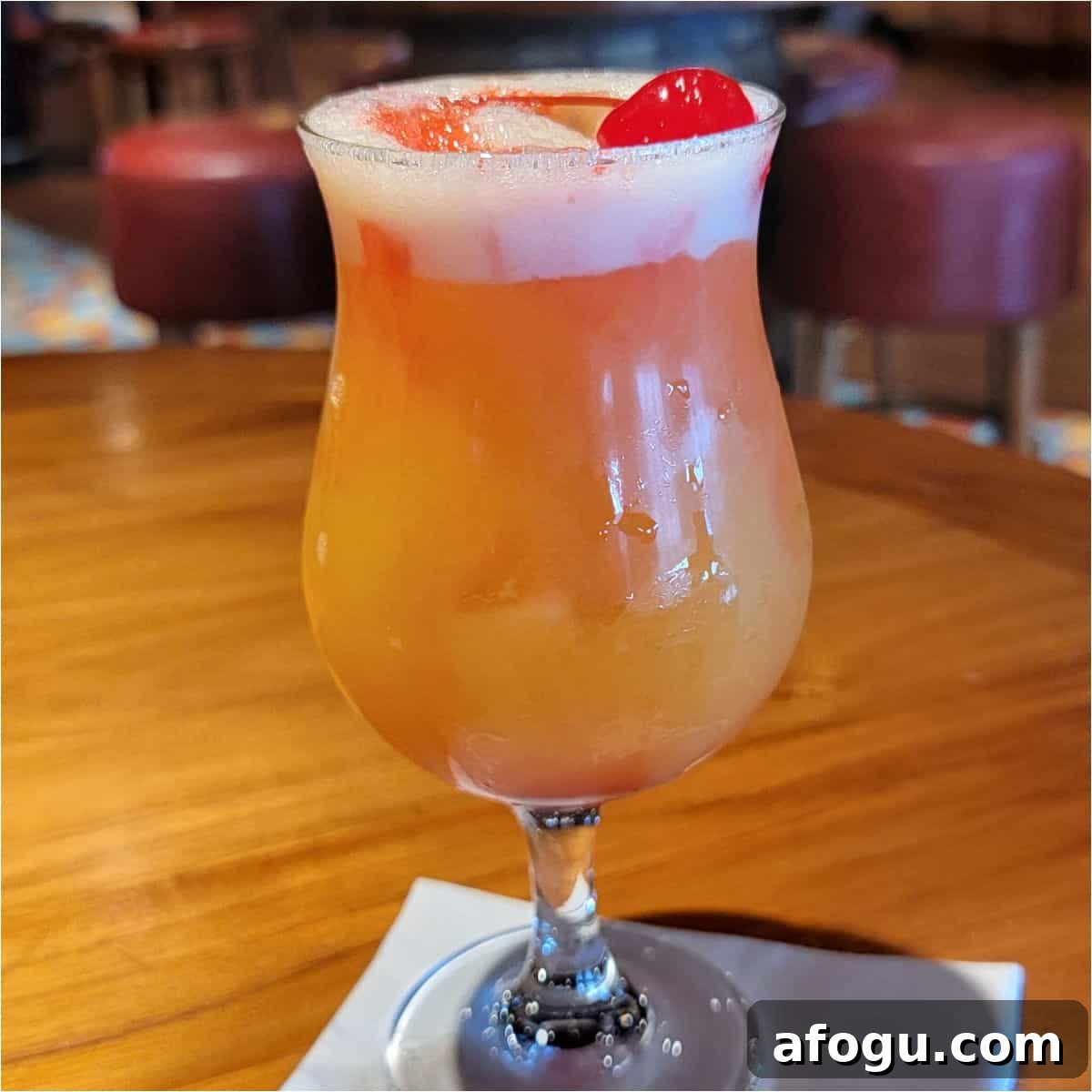 Rump Jumper cocktail in a hurricane glass garnished with a cherry