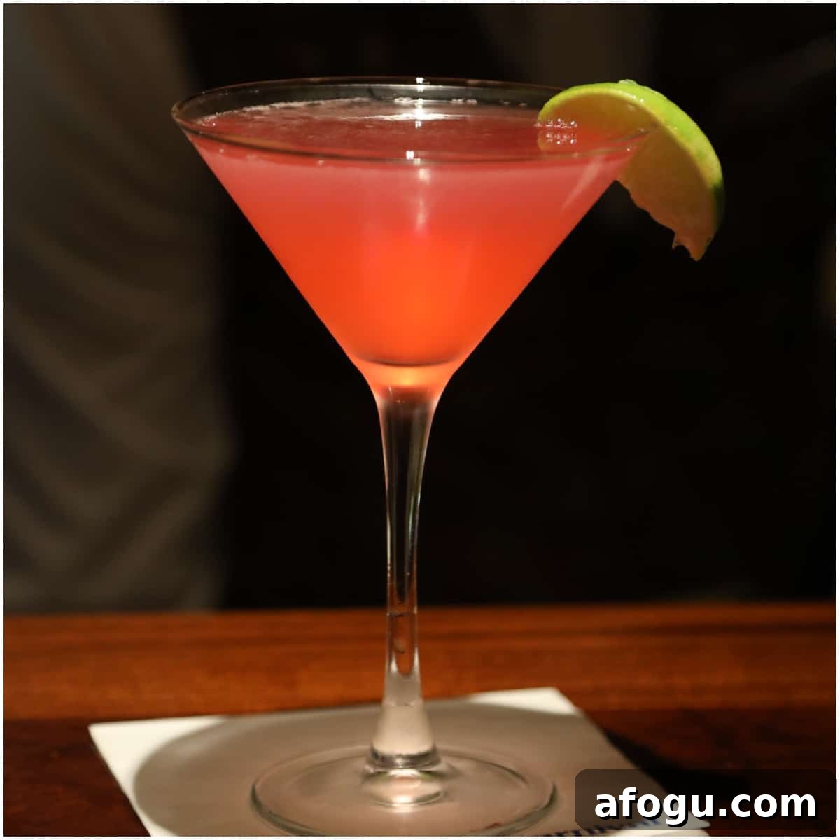 Pink martini in a martini glass with lime wedge
