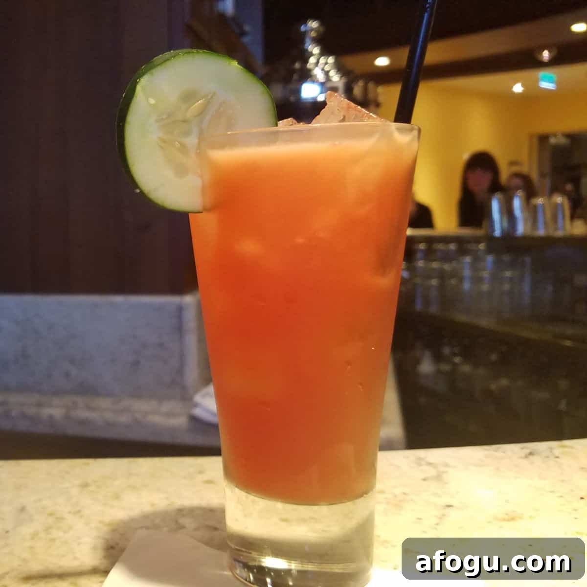 Cucumber Sunrise in a tall glass with a cucumber wheel garnish