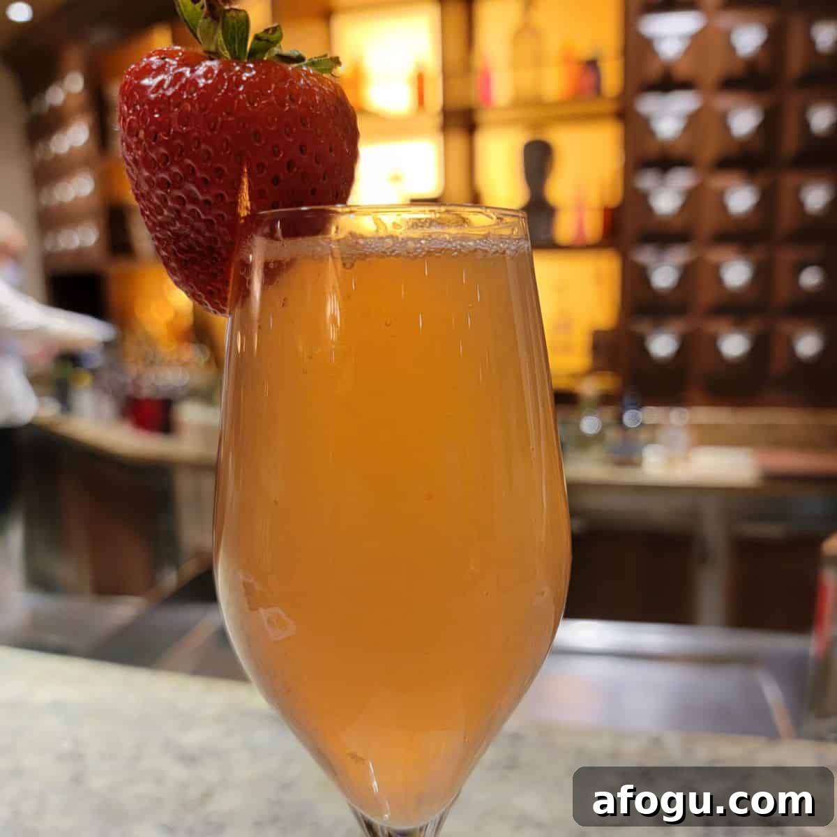French Kiss cocktail in a champagne flute with a strawberry garnish