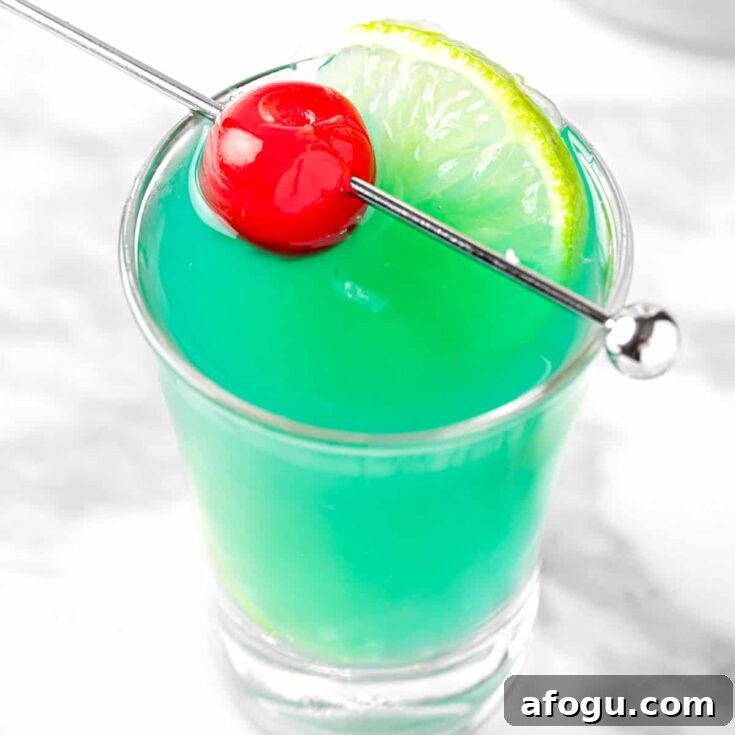 Malibu rum shooters garnished with a maraschino cherry.
