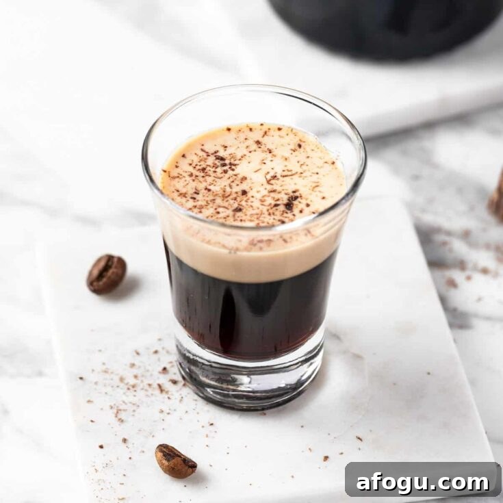 A Mudslide Shot topped with chocolate shavings on a white table.