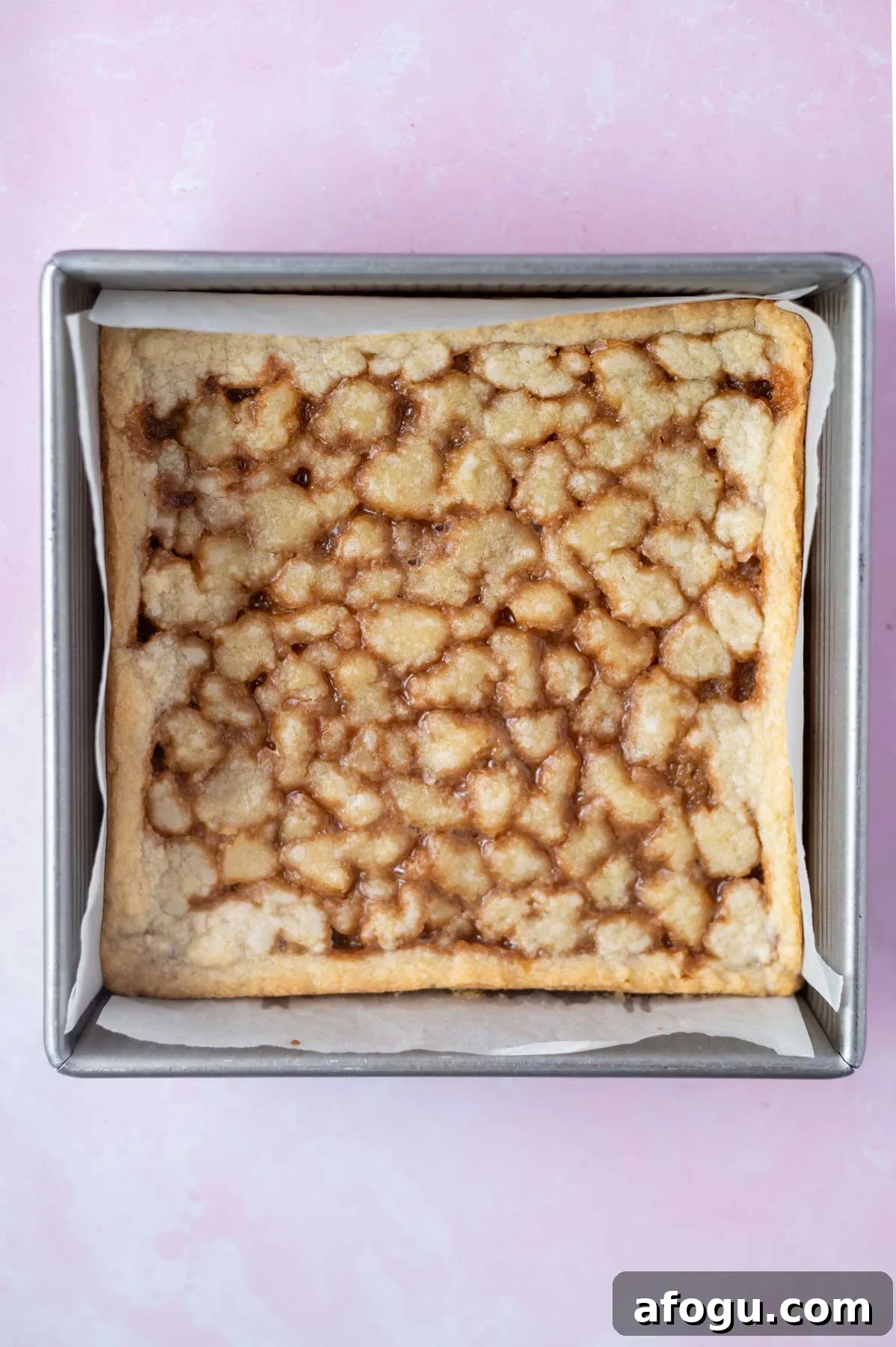baked caramel cookie bars in a parchment lined 8x8 pan