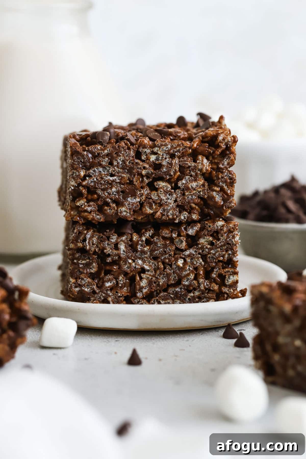 gluten-free chocolate rice krispies treats stacked on a white dessert plate