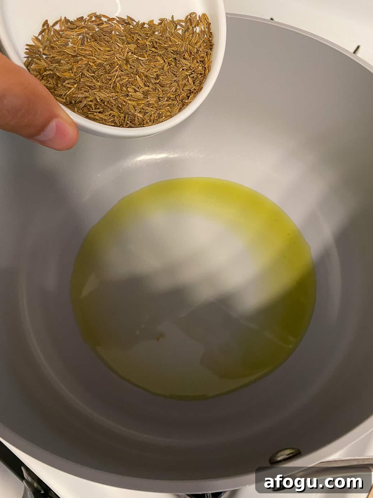 process of adding cumin seed to pan