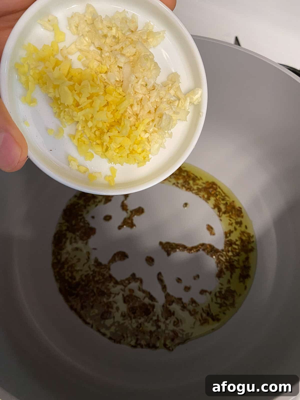 process of adding minced garlic to pan