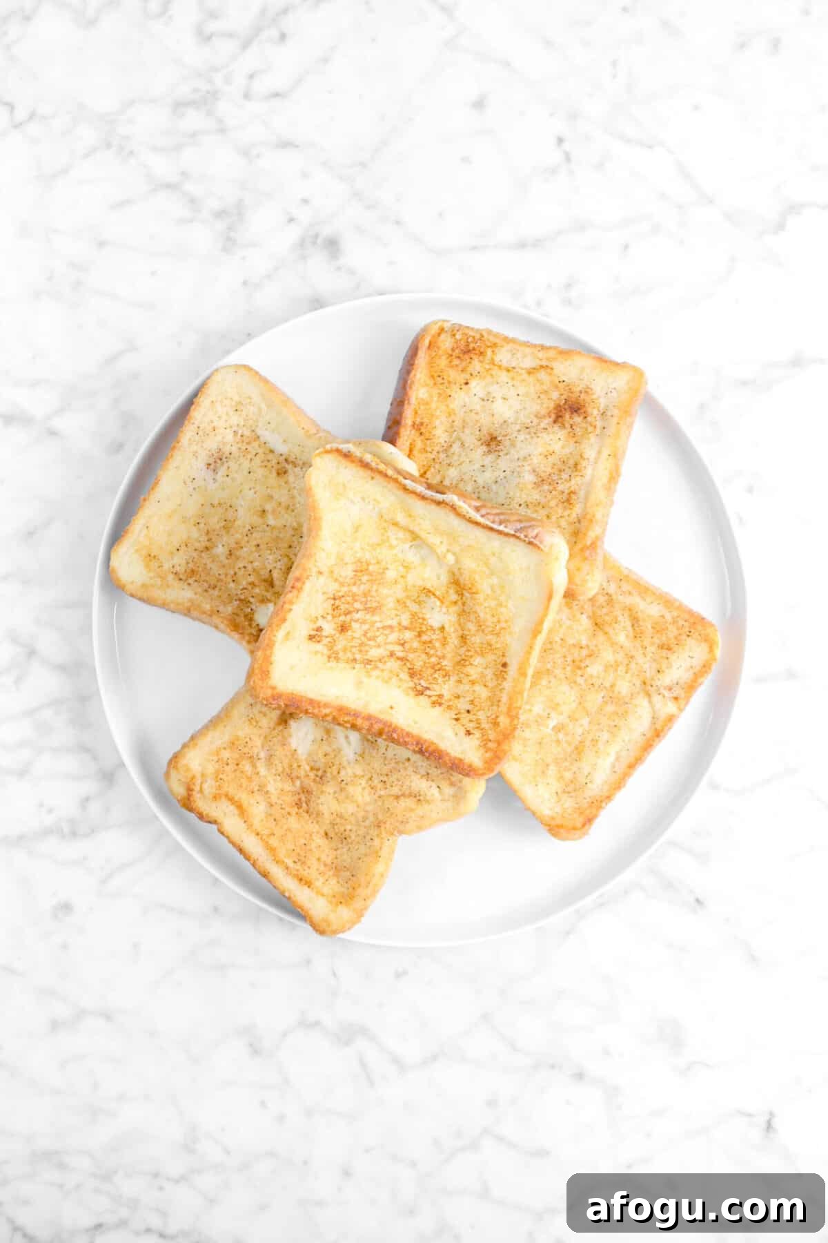 Eggnog French Toast Recipe: Festive Holiday Brunch Idea 5 five pieces of french toast on white plate