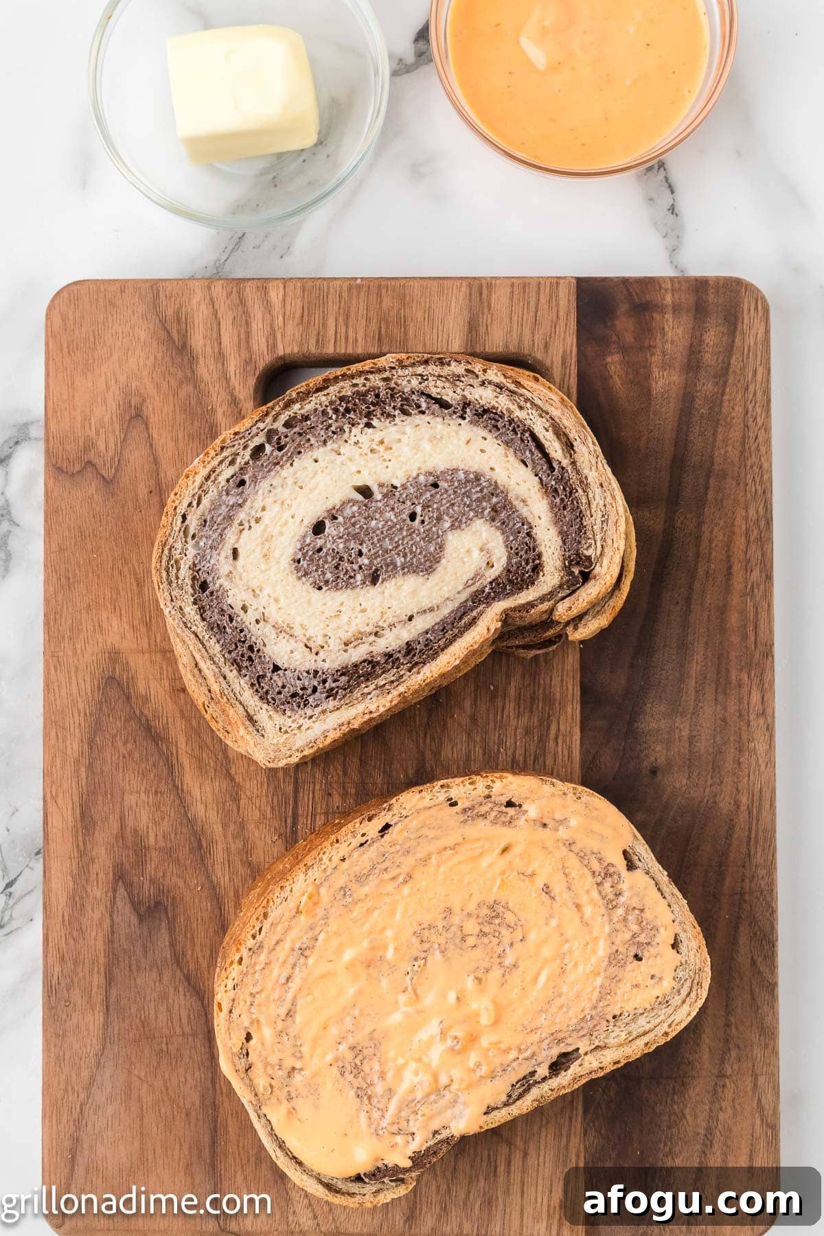 Thousand Island Dressing spread on the rye bread stacked on a cutting board