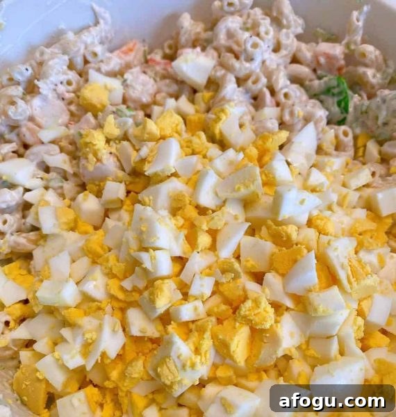 Adding hard boiled eggs to the salad mixture.