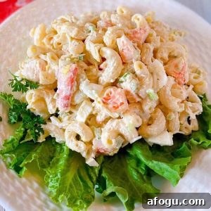 Close up photo of a plate full of the best seafood pasta salad on a bed of lettuce.