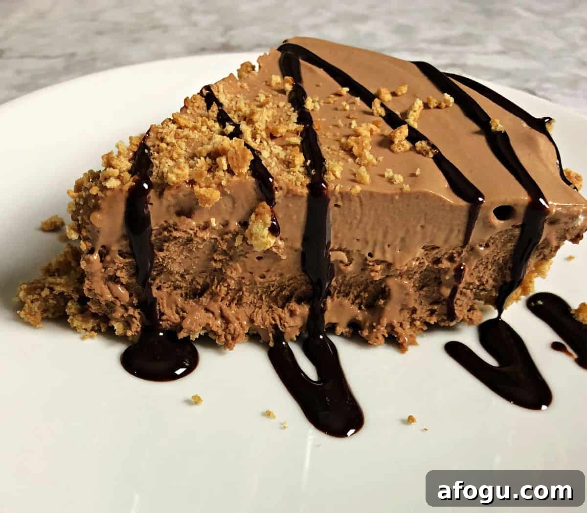 Frozen S’mores Pie Recipe: No-Bake Chocolate Graham Dessert 2 slice of s'mores pie drizzled with chocolate on a white plate